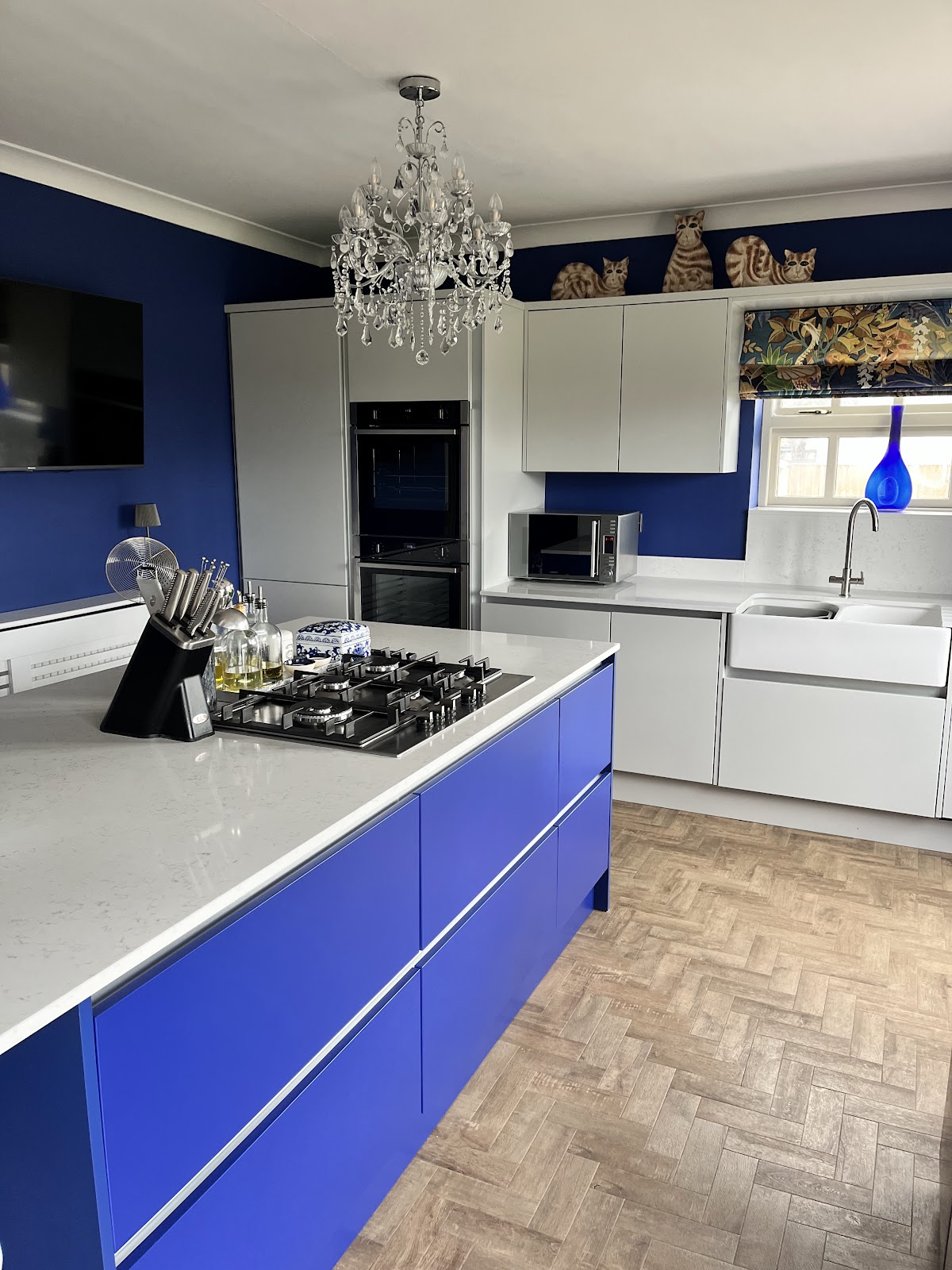 Cobalt-blue handleless island kitchen with white quartz worktop